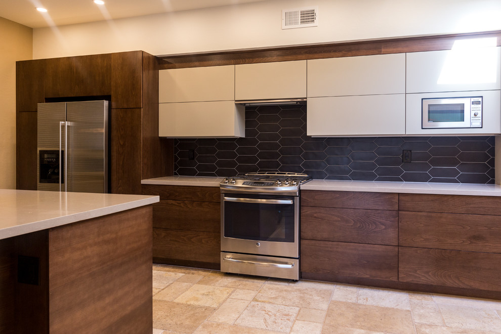 Large trendy l-shaped travertine floor and beige floor open concept kitchen photo in Phoenix with an undermount sink, flat-panel cabinets, white cabinets, quartz countertops, black backsplash, stainless steel appliances, a peninsula and white countertops