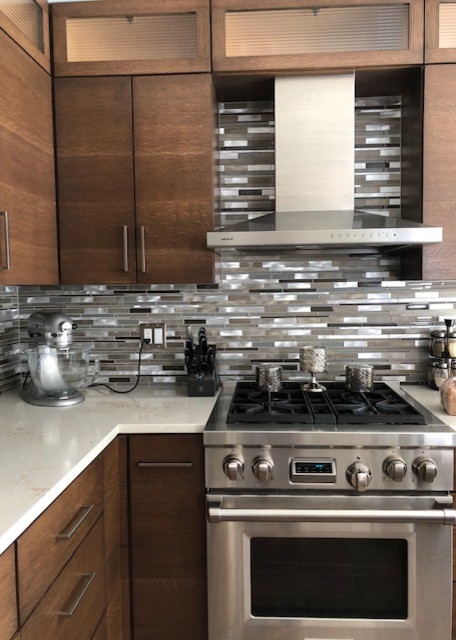 Mid-sized modern l-shaped separate kitchen in New York with an undermount sink, flat-panel cabinets, medium wood cabinets, quartz benchtops, grey splashback, matchstick tile splashback, stainless steel appliances, with island, brown floor and white benchtop.