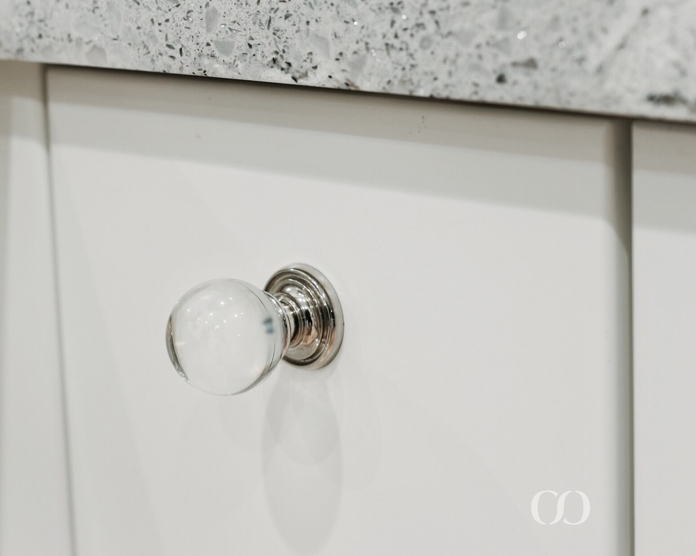 Inspiration for a mid-sized transitional l-shaped light wood floor open concept kitchen remodel with an undermount sink, recessed-panel cabinets, white cabinets, quartz countertops, blue backsplash, glass sheet backsplash, paneled appliances and an island