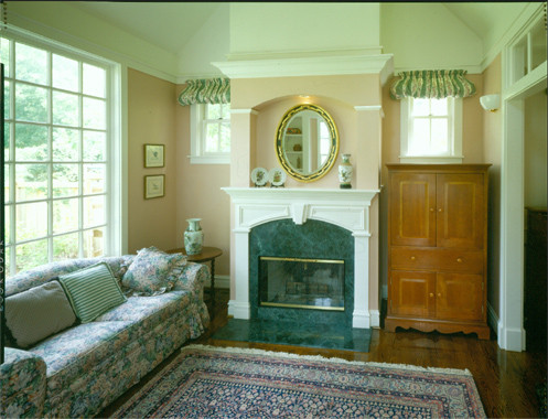 Photo of a mid-sized traditional enclosed family room in Chicago with beige walls, dark hardwood floors, a standard fireplace and a stone fireplace surround.