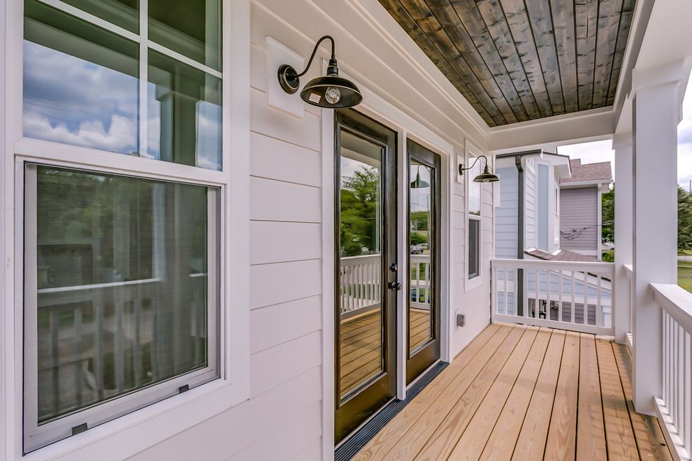 Photo of a mid-sized traditional balcony in Nashville with a roof extension and wood railing.