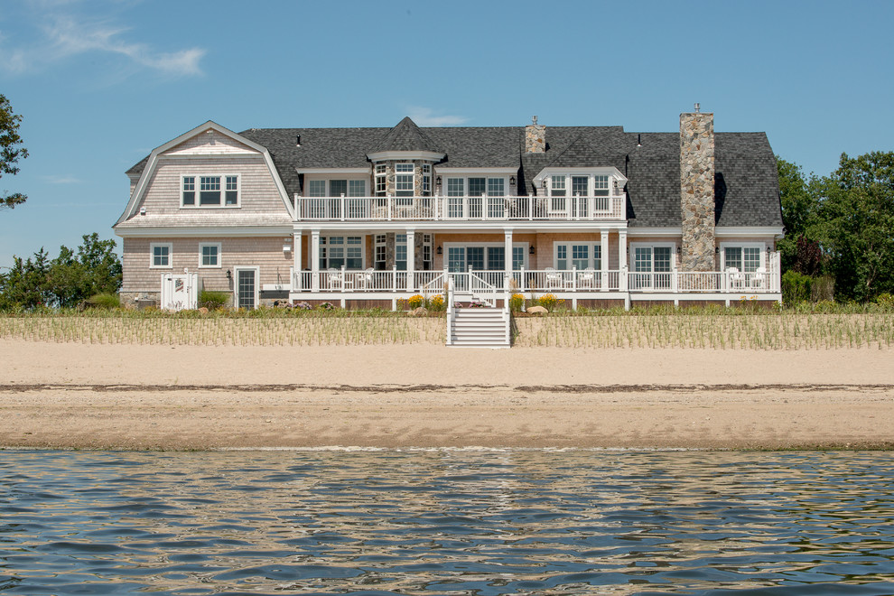 Design ideas for a large beach style two-storey beige house exterior in Boston with wood siding, a gambrel roof and a shingle roof.