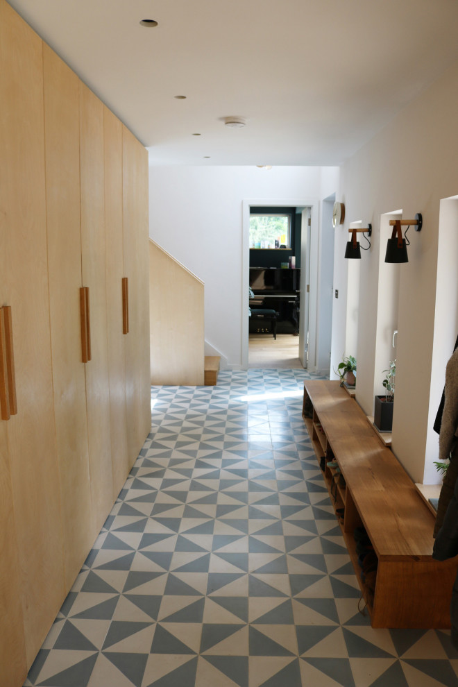 Стильный дизайн: большой коридор в современном стиле с полом из керамической плитки, синим полом и деревянными стенами - последний тренд