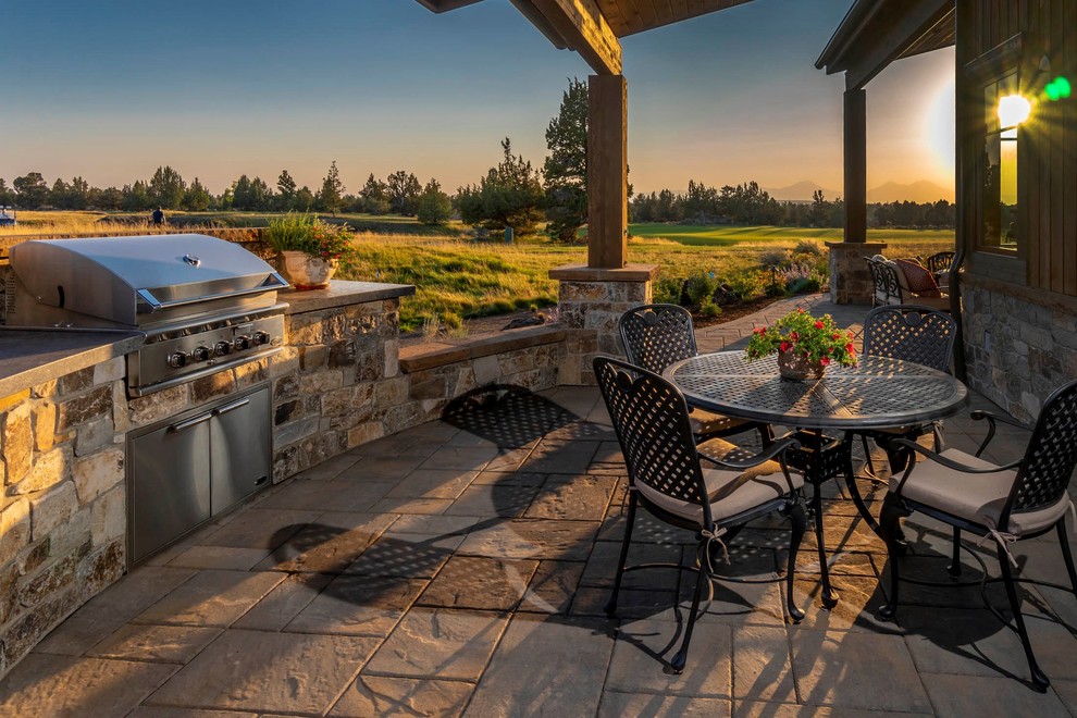 Inspiration for a large rustic backyard stone patio remodel with a fireplace and a roof extension