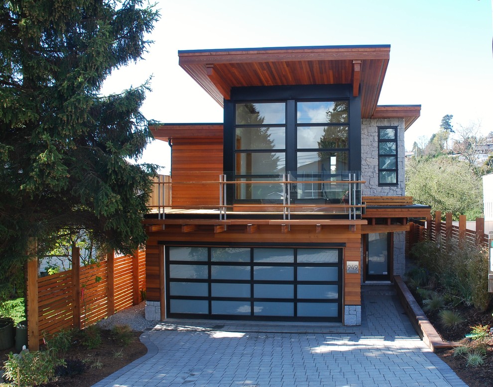 Design ideas for a mid-sized modern two-storey brown exterior in Vancouver with wood siding and a flat roof.