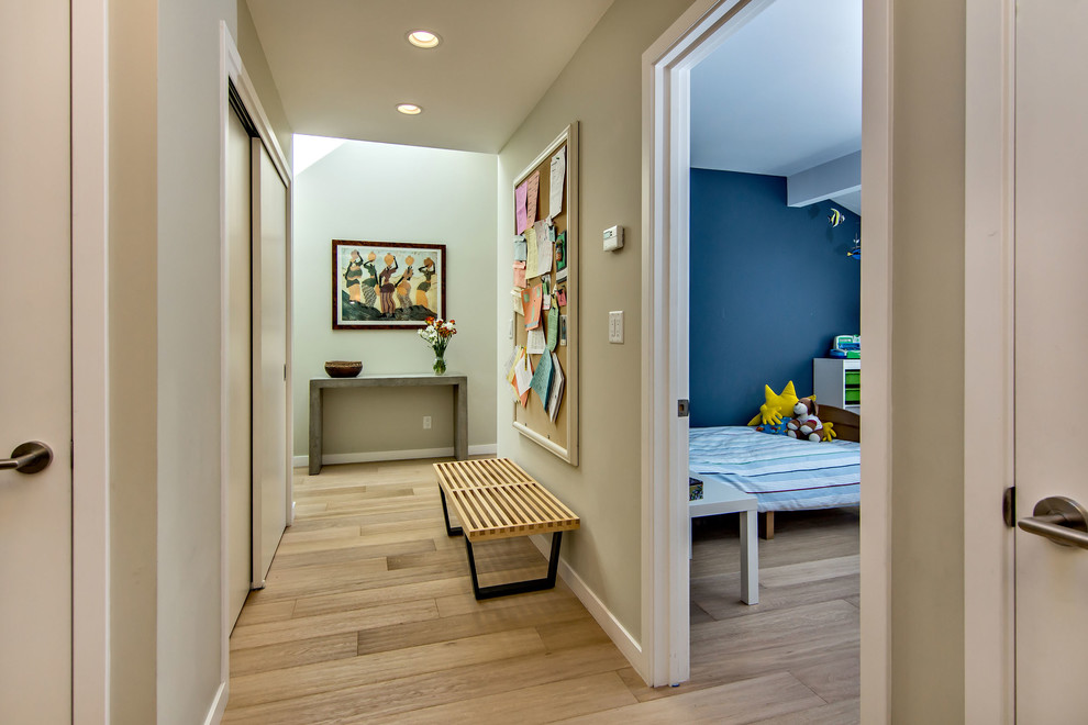 Photo of a mid-sized midcentury hallway in San Francisco with grey walls, light hardwood floors and beige floor.