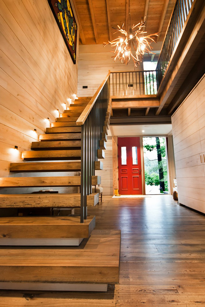 Imagen de escalera sin contrahuella con escalones de madera y barandilla de metal