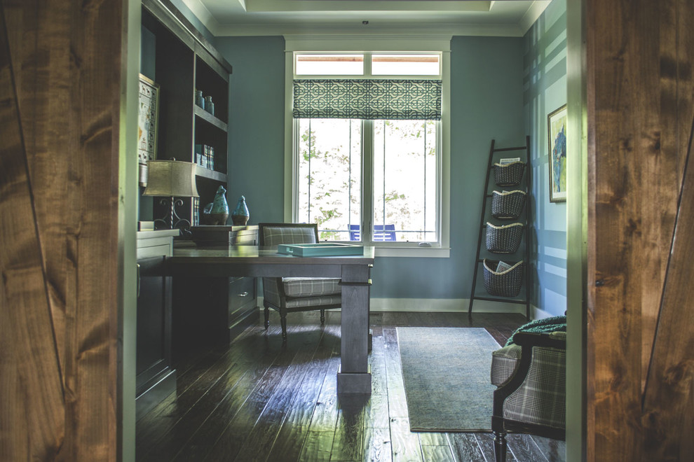 Mid-sized study room in Louisville with blue walls, medium hardwood floors, a built-in desk and brown floor.