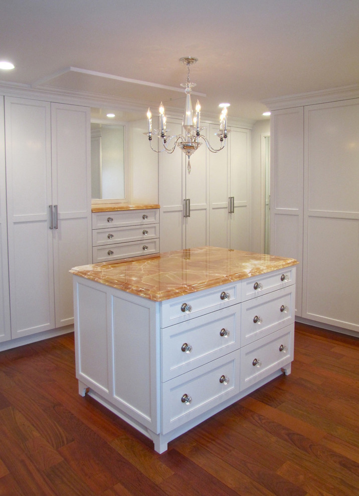 This is an example of a large traditional gender-neutral walk-in wardrobe in DC Metro with shaker cabinets, white cabinets, medium hardwood floors and brown floor.