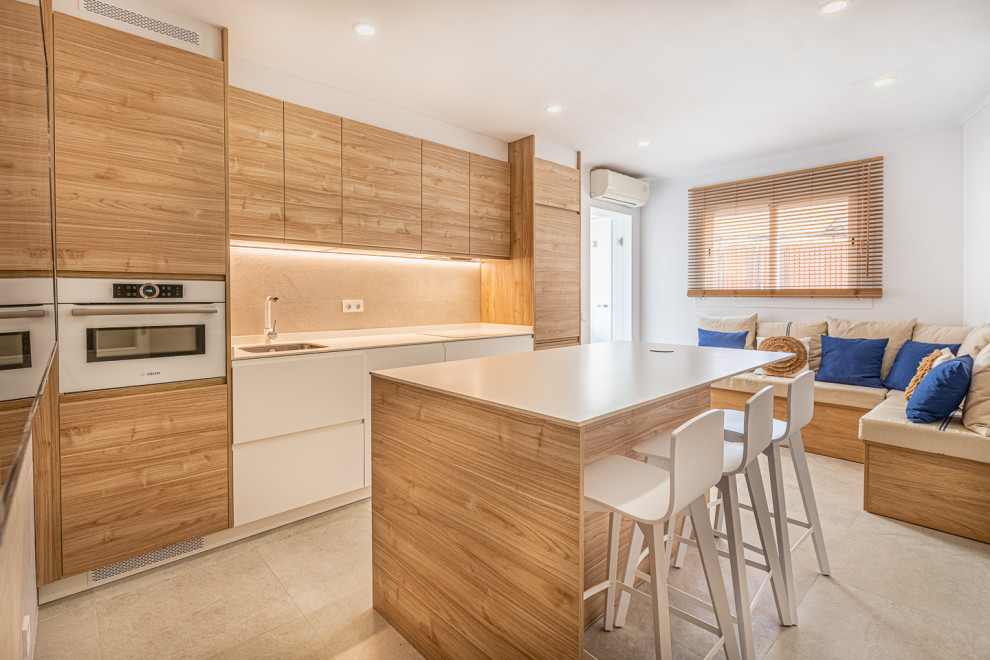 Foto di un cucina con isola centrale minimalista di medie dimensioni con lavello sottopiano, ante in legno scuro, top in marmo, elettrodomestici bianchi, pavimento in cemento e top bianco