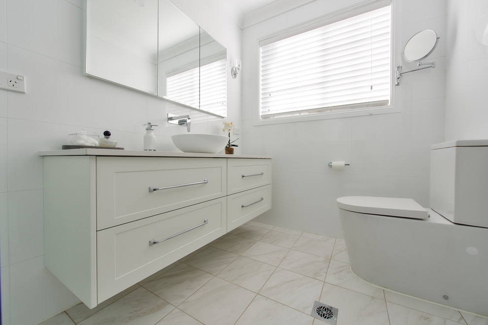 This is an example of a large contemporary master l-shaped bathroom in Sydney with an undermount sink, shaker cabinets, quartz benchtops, white splashback, glass sheet splashback, stainless steel appliances, dark hardwood floors, with island, brown floor, white cabinets, a freestanding tub, a corner shower, white tile, porcelain tile, engineered quartz benchtops and an open shower.