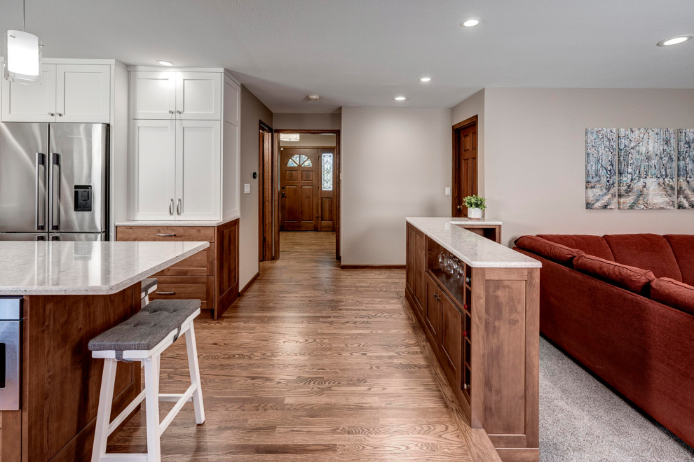 This is an example of a small classic u-shaped kitchen in Seattle with a submerged sink, shaker cabinets, medium wood cabinets, engineered stone countertops, white splashback, marble splashback, stainless steel appliances, medium hardwood flooring, an island, brown floors and beige worktops.