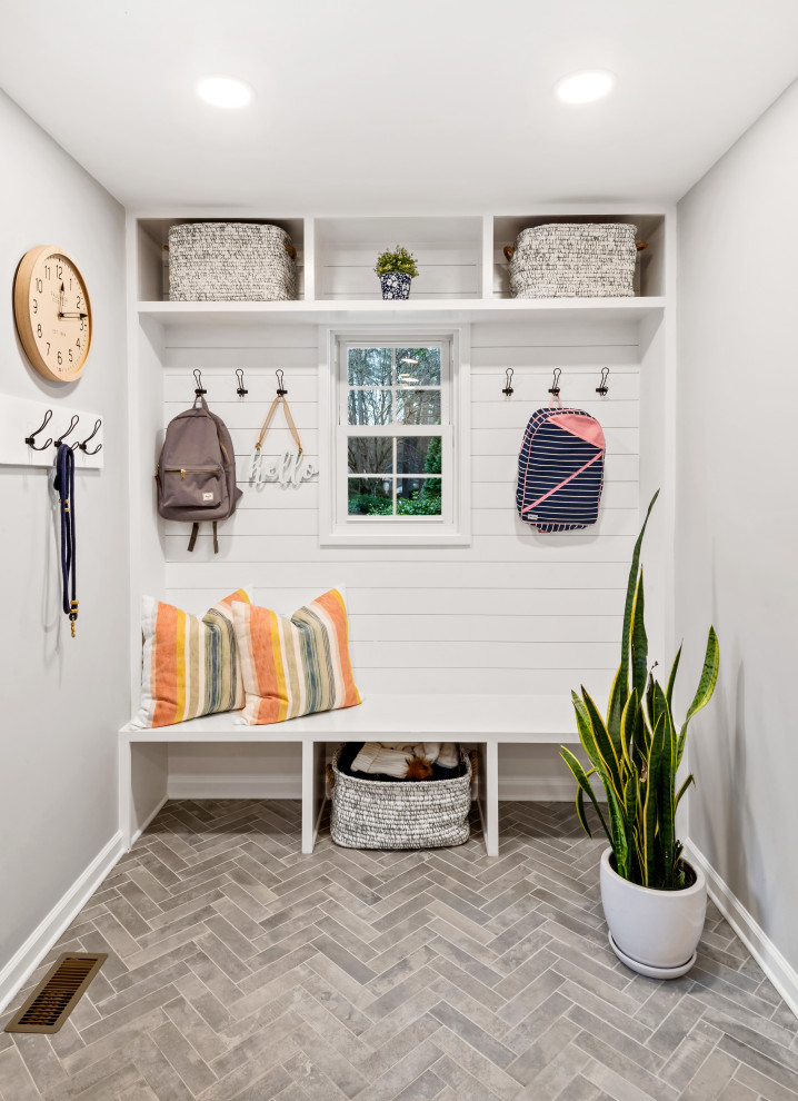 Beach style mudroom in Raleigh with porcelain floors, grey floor, white walls and planked wall panelling.