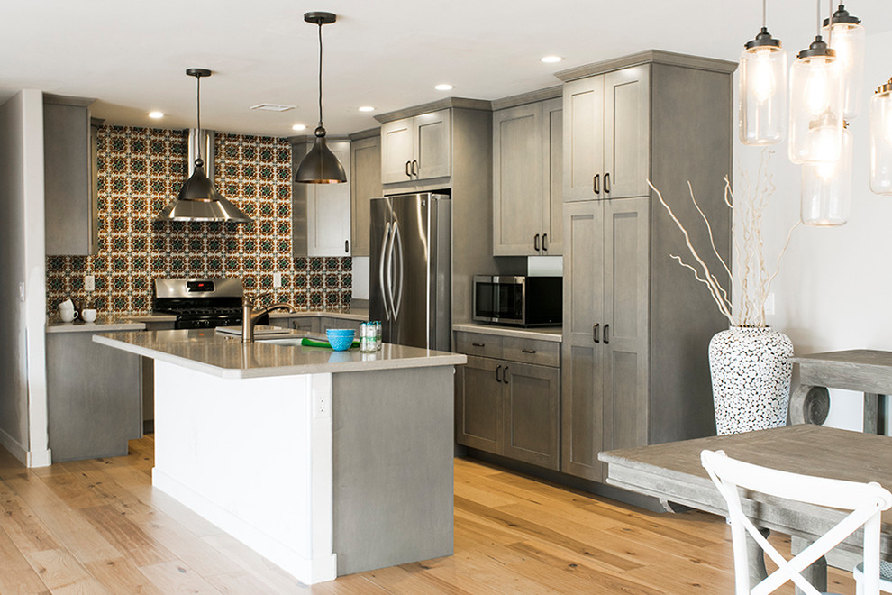 Eat-in kitchen - mid-sized transitional l-shaped light wood floor and beige floor eat-in kitchen idea in Phoenix with an undermount sink, shaker cabinets, gray cabinets, granite countertops, multicolored backsplash, ceramic backsplash, stainless steel appliances and an island