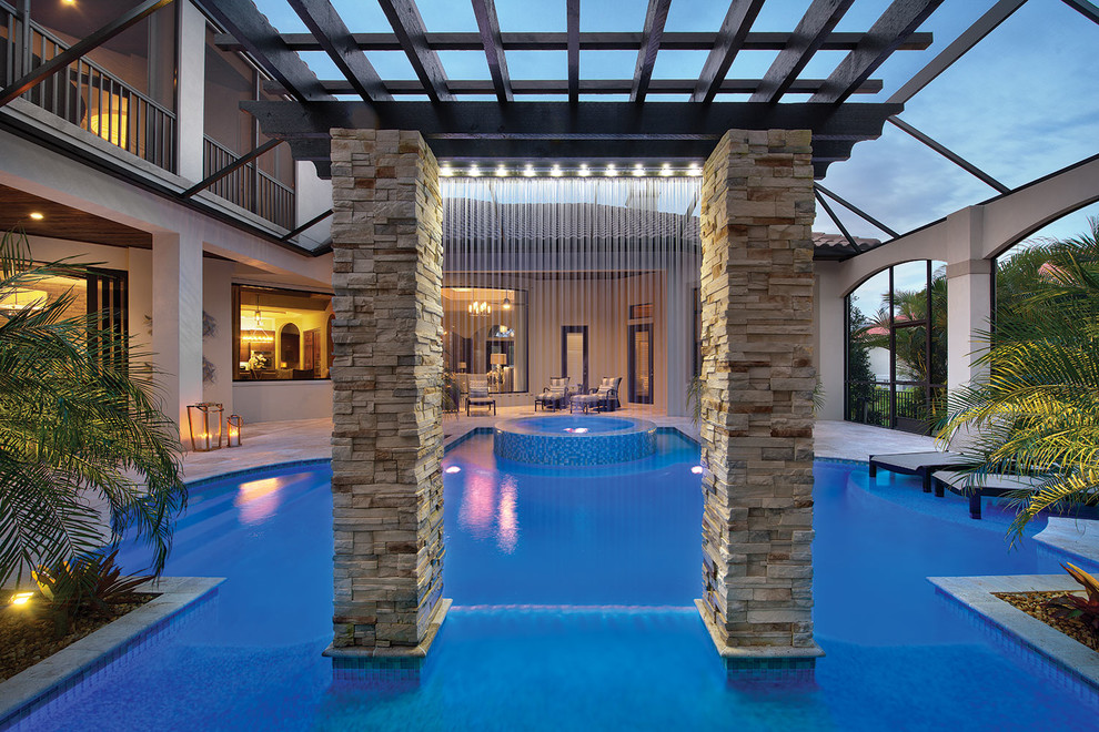 Inspiration for a mediterranean backyard custom-shaped pool in Tampa with a water feature and tile.