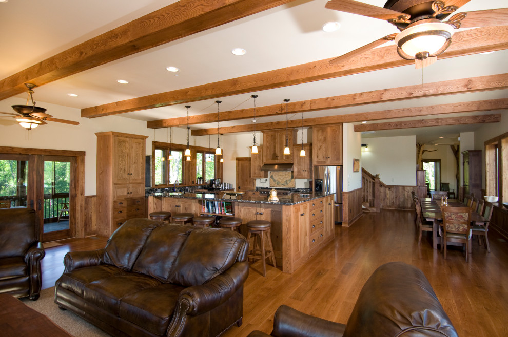 Eat-in kitchen - l-shaped medium tone wood floor, brown floor and exposed beam eat-in kitchen idea with a double-bowl sink, flat-panel cabinets, brown cabinets, multicolored backsplash, mosaic tile backsplash, stainless steel appliances, an island and multicolored countertops