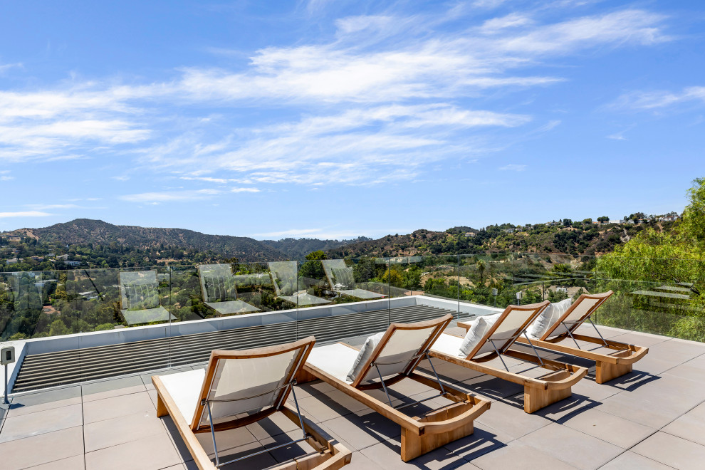 Inspiration for an expansive modern rooftop and rooftop deck in Los Angeles with no cover and glass railing.