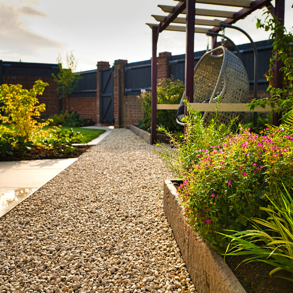 Foto di un giardino xeriscape minimal esposto a mezz'ombra di medie dimensioni e dietro casa in estate con ghiaia e recinzione in pietra