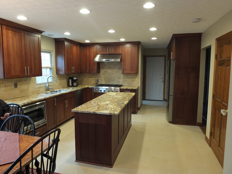 Inspiration for a mid-sized transitional l-shaped ceramic tile eat-in kitchen remodel in Columbus with an undermount sink, shaker cabinets, brown cabinets, granite countertops, beige backsplash, ceramic backsplash, stainless steel appliances and an island