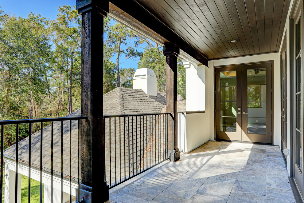 Inspiration for a large transitional balcony in Houston with a roof extension and metal railing.