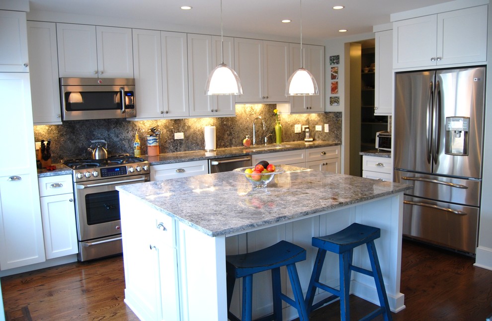 Inspiration for a transitional l-shaped eat-in kitchen remodel in Chicago with an undermount sink, shaker cabinets, white cabinets, granite countertops, stone slab backsplash and stainless steel appliances