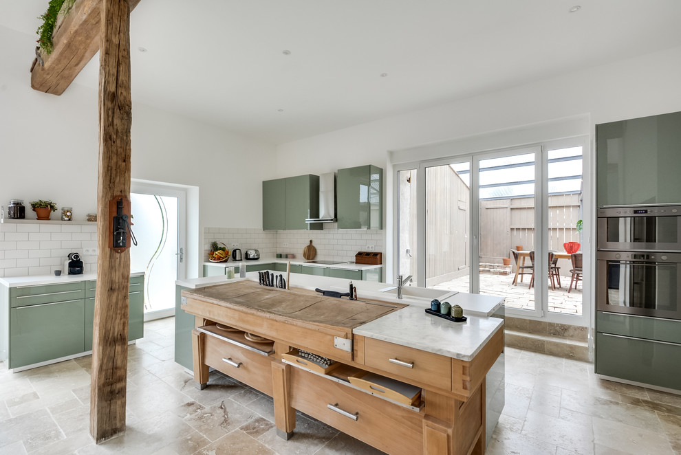 Expansive scandinavian l-shaped open plan kitchen in Other with a double-bowl sink, beaded inset cabinets, green cabinets, laminate benchtops, white splashback, porcelain splashback, stainless steel appliances, marble floors, with island and beige floor.