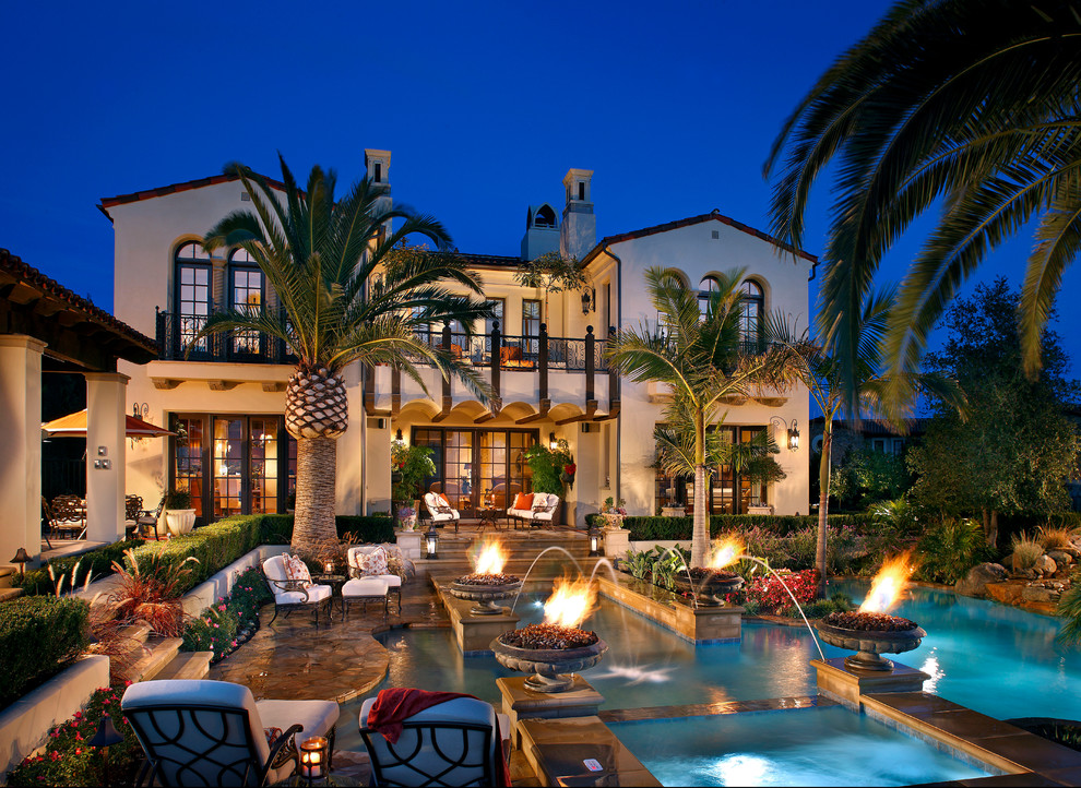 This is an example of a large mediterranean custom-shaped pool in Orange County with natural stone pavers.
