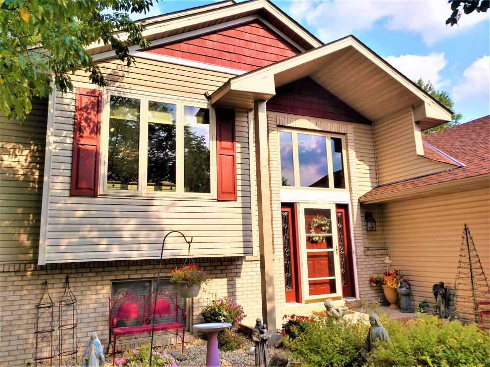 Aménagement d'une façade de maison multicolore rétro de taille moyenne et à niveaux décalés avec un revêtement mixte, un toit en shingle et un toit rouge.