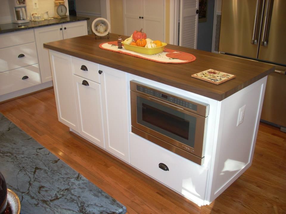 Kitchen - mid-sized galley medium tone wood floor kitchen idea in DC Metro with white cabinets, wood countertops, white backsplash, ceramic backsplash, stainless steel appliances and an island