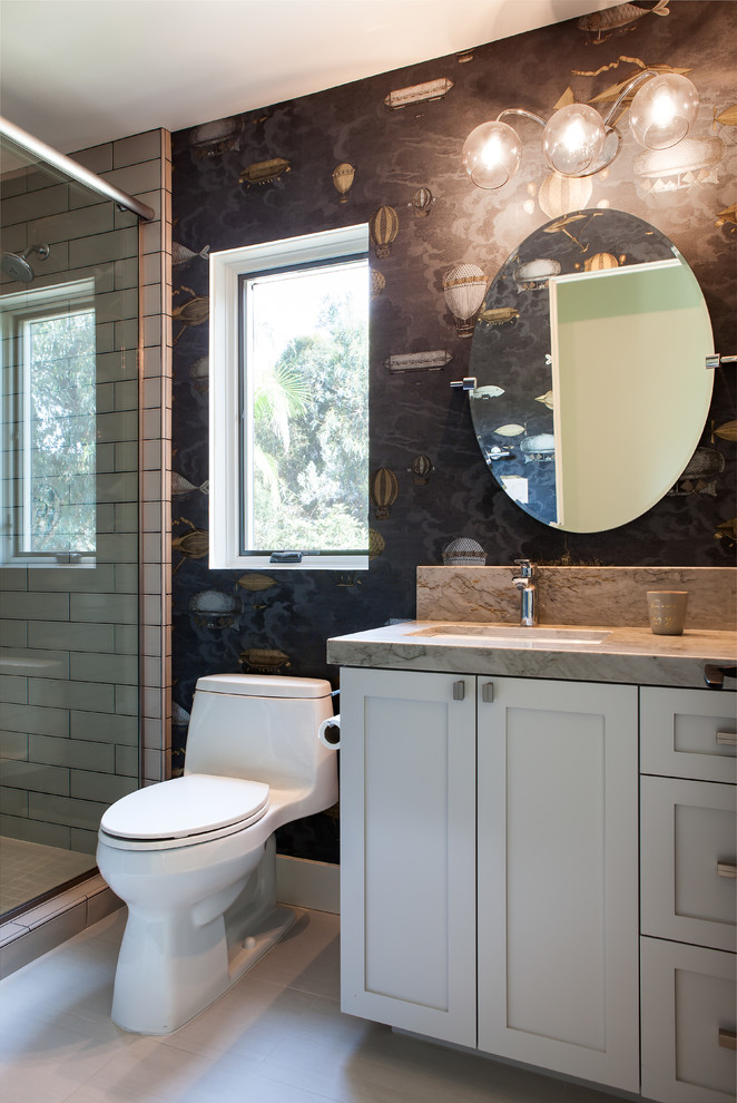 Design ideas for a small transitional kids bathroom in San Diego with shaker cabinets, grey cabinets, an alcove tub, a shower/bathtub combo, a one-piece toilet, beige tile, porcelain tile, white walls, porcelain floors, an undermount sink and quartzite benchtops.