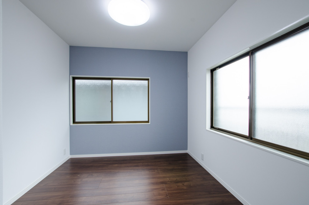 Idéer för att renovera ett litet minimalistiskt barnrum kombinerat med skrivbord, med blå väggar, mörkt trägolv och brunt golv