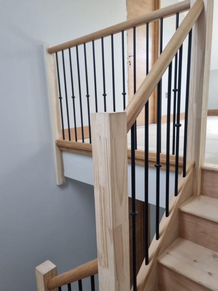 Идея дизайна: большая изогнутая лестница в современном стиле с деревянными ступенями и металлическими перилами без подступенок