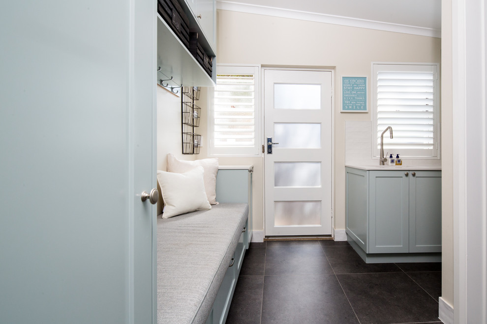 Mid-sized contemporary l-shaped utility room in Brisbane with an undermount sink, recessed-panel cabinets, green cabinets, quartz benchtops, white walls, porcelain floors, a side-by-side washer and dryer, grey floor and white benchtop.