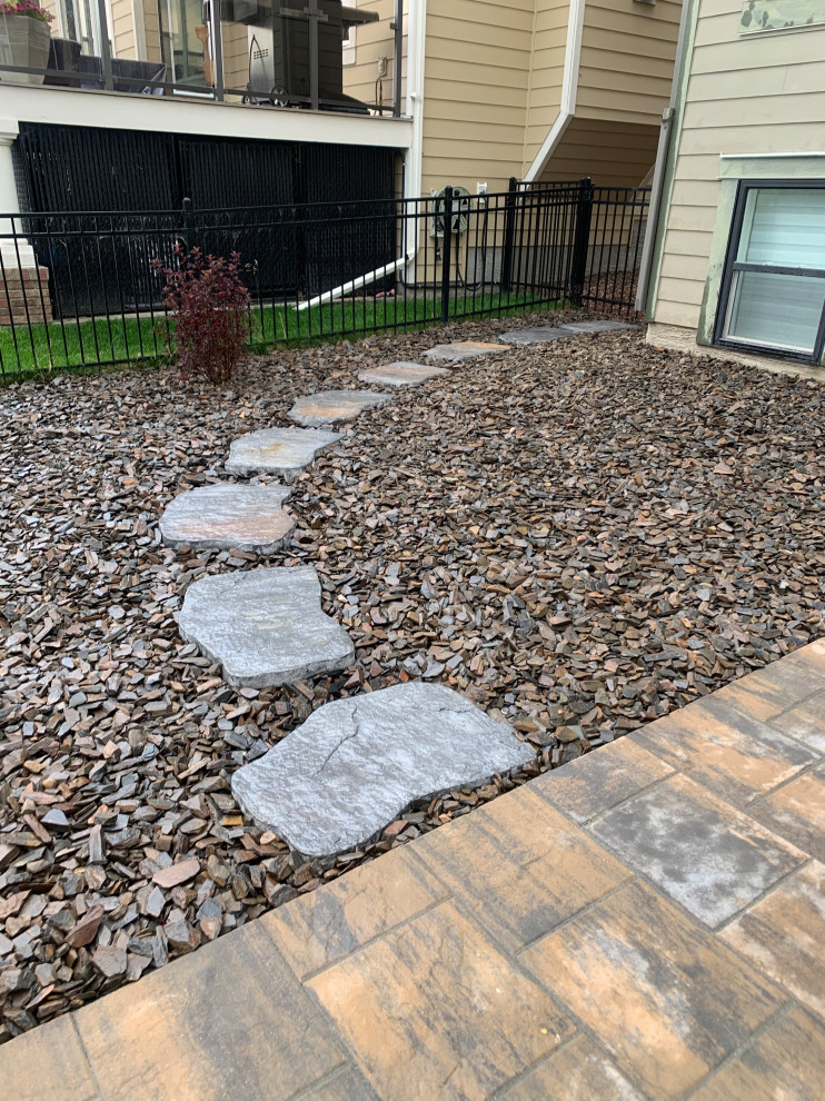 Design ideas for a medium sized classic side xeriscape full sun garden for summer in Calgary with a pathway, decomposed granite and a metal fence.