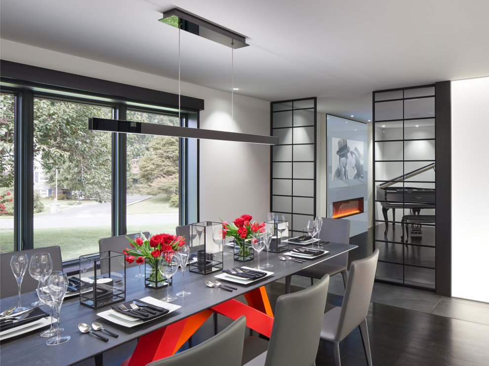 Expansive modern open plan dining in Philadelphia with grey walls, dark hardwood floors, a standard fireplace, a metal fireplace surround, black floor and recessed.