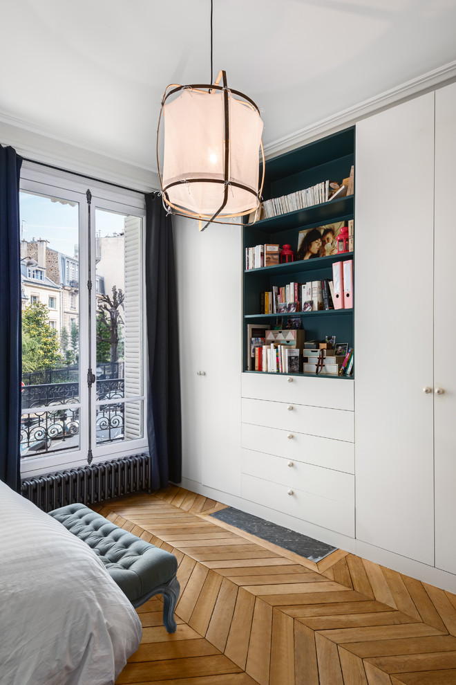 Design ideas for a mid-sized transitional master bedroom in Paris with white walls and light hardwood floors.