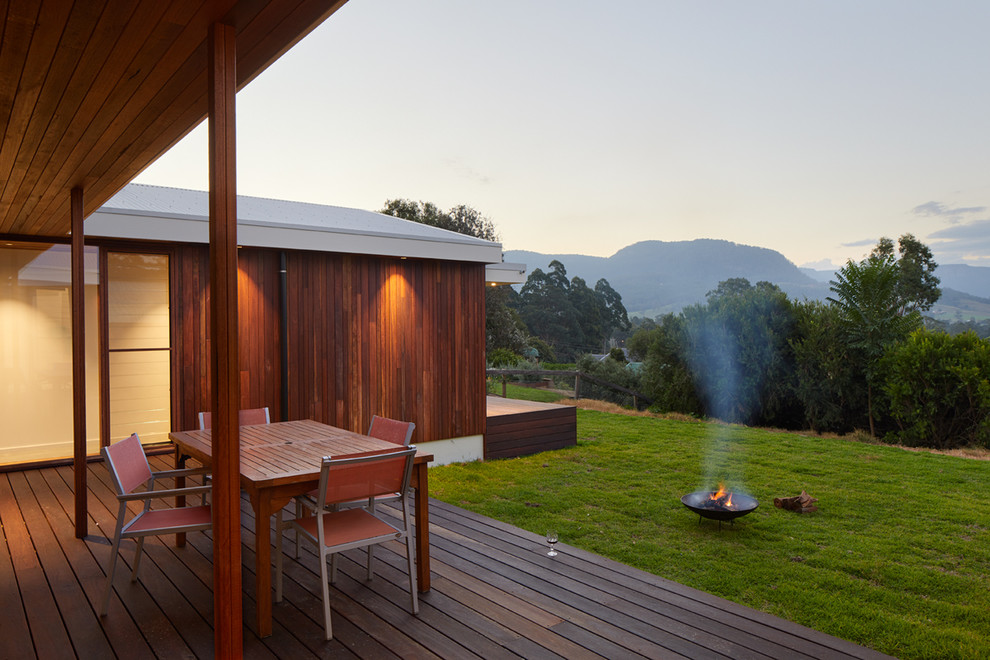Inspiration for a contemporary backyard deck in Wollongong with a fire feature and a roof extension.