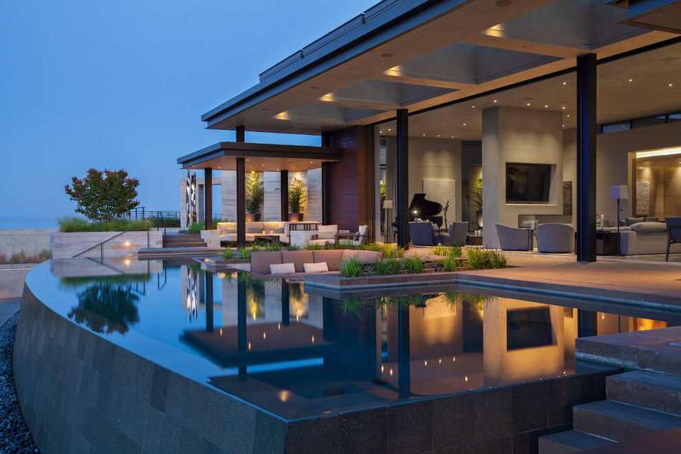 Design ideas for an expansive contemporary backyard custom-shaped infinity pool in San Francisco with concrete slab.