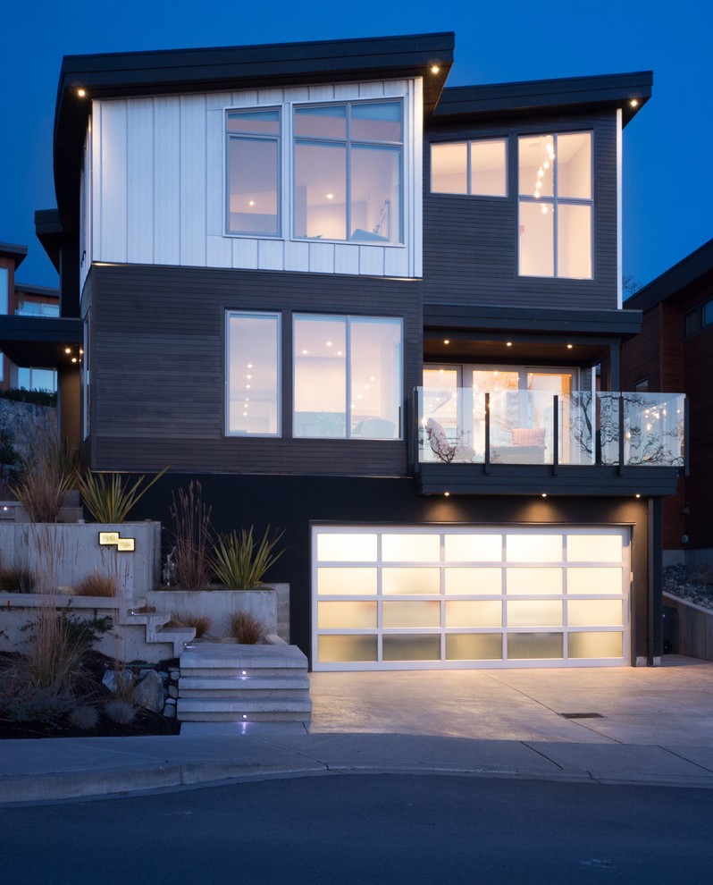 Photo of a contemporary three-storey exterior in Vancouver with mixed siding.