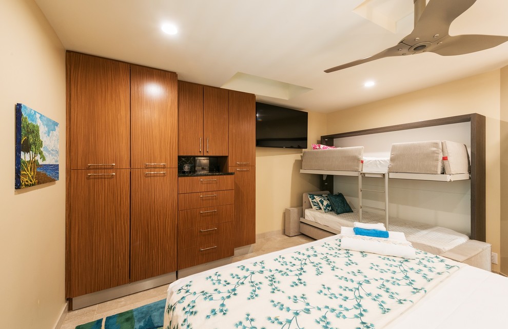 Photo of a tropical storage and wardrobe in Hawaii with flat-panel cabinets, medium wood cabinets, limestone floors and beige floor.