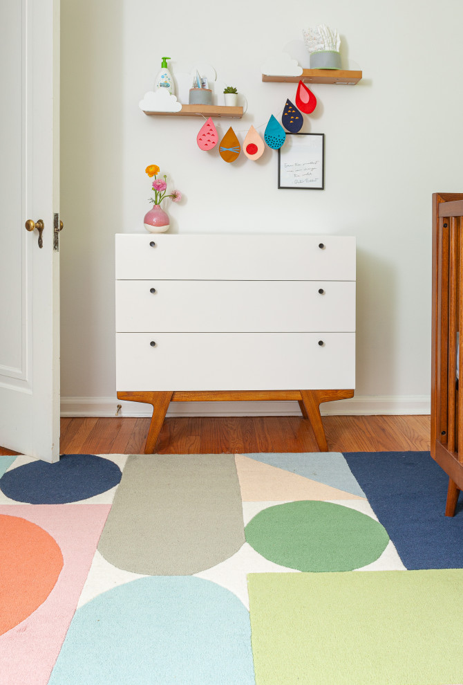 Inspiration for a small midcentury nursery for girls in Detroit with green walls, medium hardwood floors and multi-coloured floor.