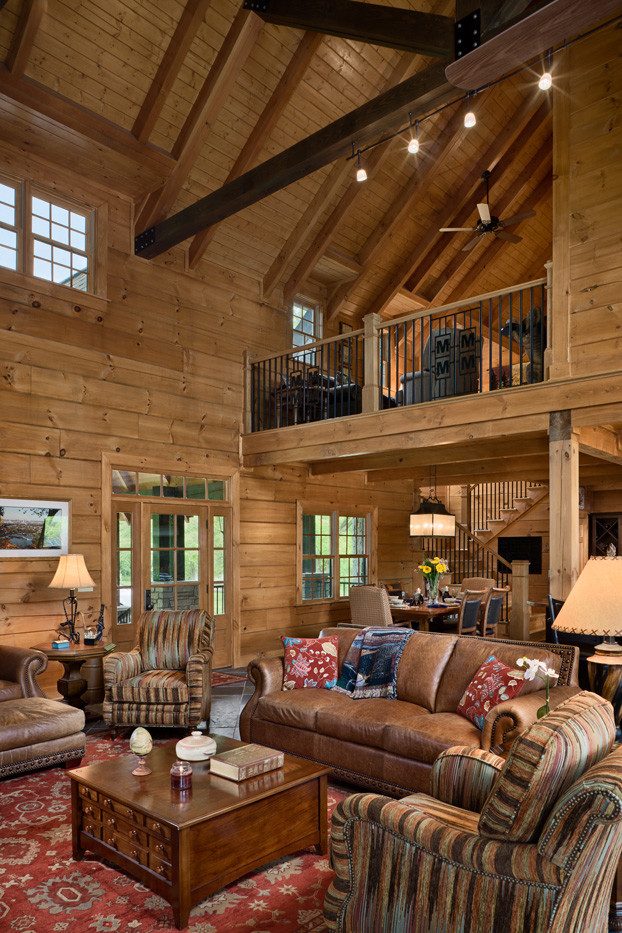 Example of a large mountain style slate floor living room design in Nashville with brown walls and a corner tv