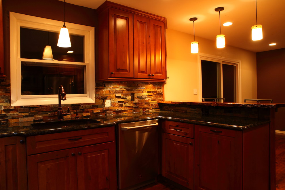 Example of a small mountain style u-shaped eat-in kitchen design with a single-bowl sink, raised-panel cabinets, medium tone wood cabinets, granite countertops, multicolored backsplash, stone slab backsplash, stainless steel appliances and no island