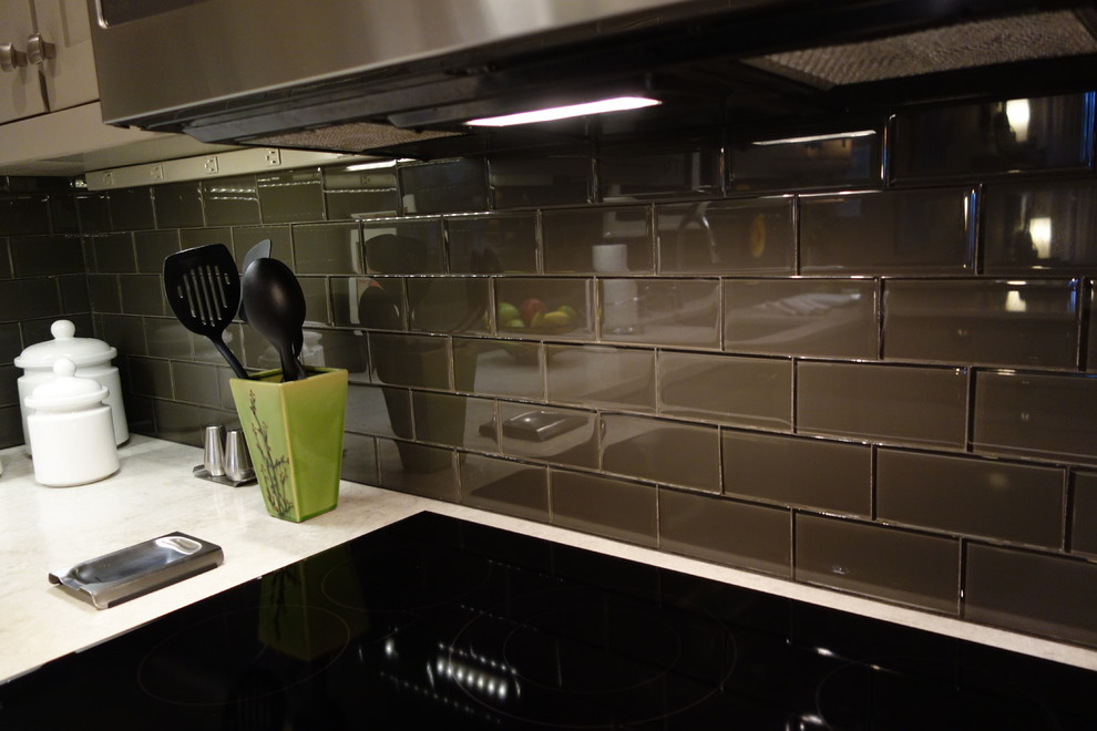 Inspiration for a small transitional u-shaped ceramic tile home design remodel with an undermount sink, shaker cabinets, gray cabinets, quartz countertops, gray backsplash, glass tile backsplash, stainless steel appliances and a peninsula