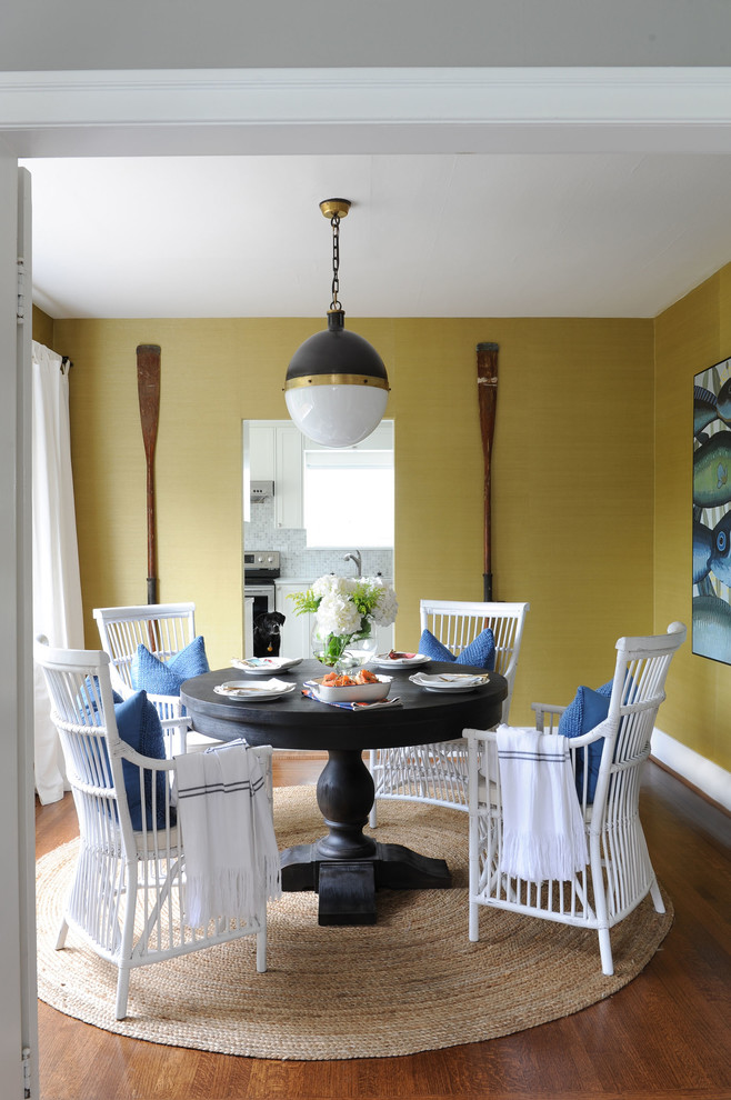 Transitional medium tone wood floor and brown floor dining room photo with yellow walls