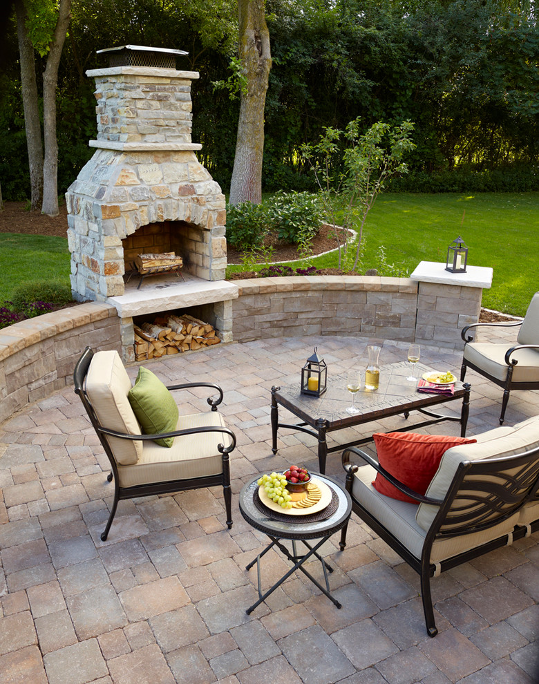 This is an example of a small transitional backyard patio in Minneapolis with a fire feature, concrete pavers and no cover.