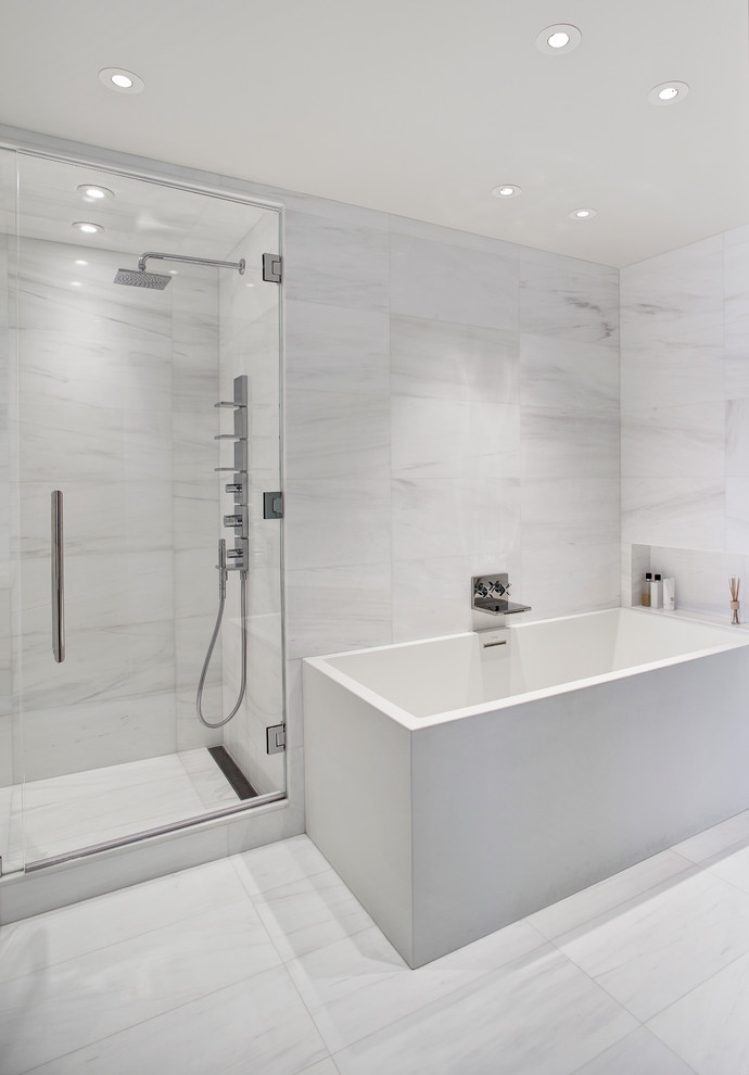Photo of a contemporary master bathroom in New York with an alcove shower, white tile, stone tile, a corner tub, marble floors, grey floor, a hinged shower door and a niche.
