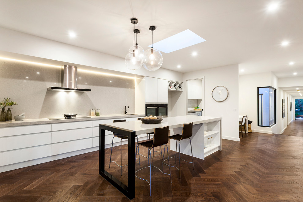 Inspiration for a large contemporary galley eat-in kitchen in Melbourne with an undermount sink, recessed-panel cabinets, white cabinets, quartz benchtops, grey splashback, stone slab splashback, black appliances, medium hardwood floors and with island.