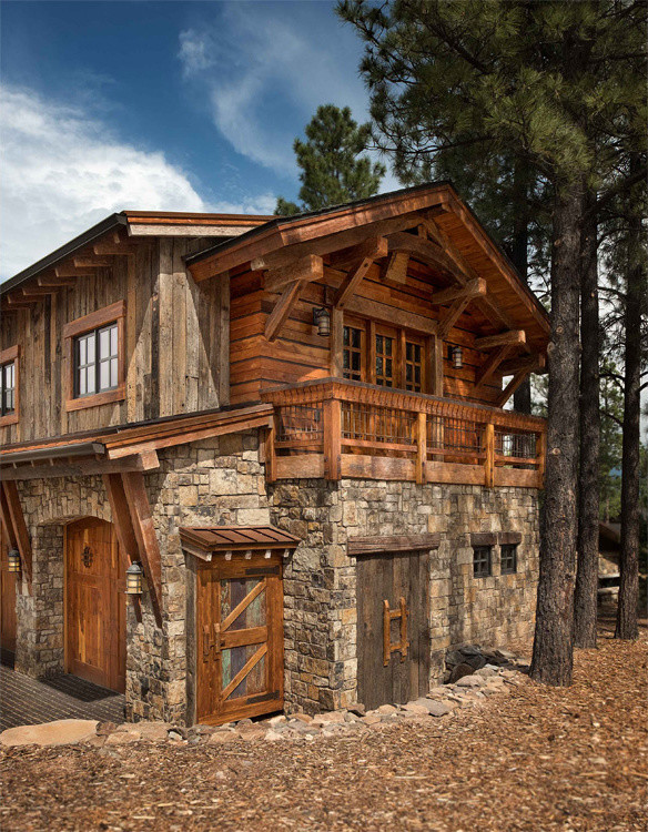 This is an example of a large country two-storey exterior in Phoenix with stone veneer.