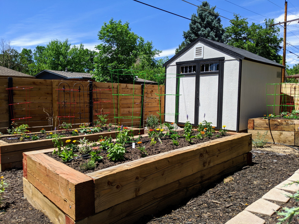 Immagine di un orto in giardino country esposto in pieno sole di medie dimensioni e dietro casa con pavimentazioni in mattoni e recinzione in legno